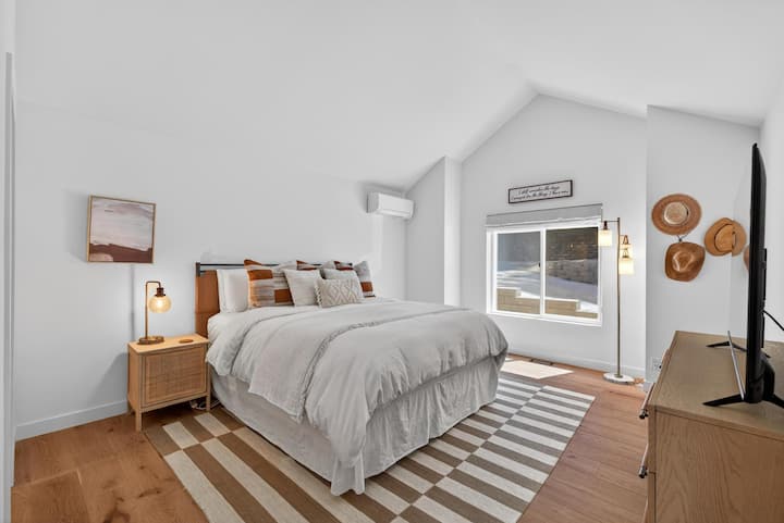 Main level king suite with smart TV and ensuite bathroom featuring a walk-in shower.