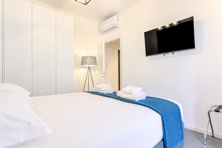 Dormitorio moderno y relajante con una cama tamaño king, colchón y almohadas cómodos, un gran armario y aire acondicionado para una estancia confortable.
