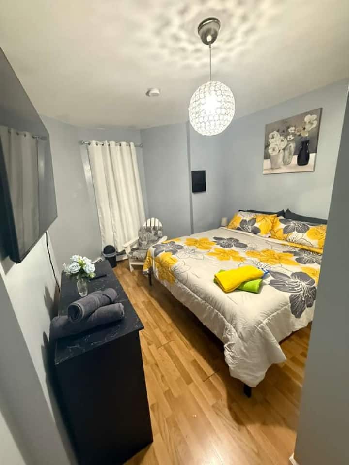 Šviesus, elegantiškas kambarys su karališka lova, švariais patalynės užvalkalais, geltonai pilko atspalvio dekoru, medinėmis grindimis, televizoriumi, kėde, šiukšliadėžėmis ir meno kūriniais ant sienų. Juoda skrynia su rankšluosčiais ir krištolo šviestuvas sustiprina jaukią aplinką, siūlydami ramią ir atpalaiduojančią viešnagę.