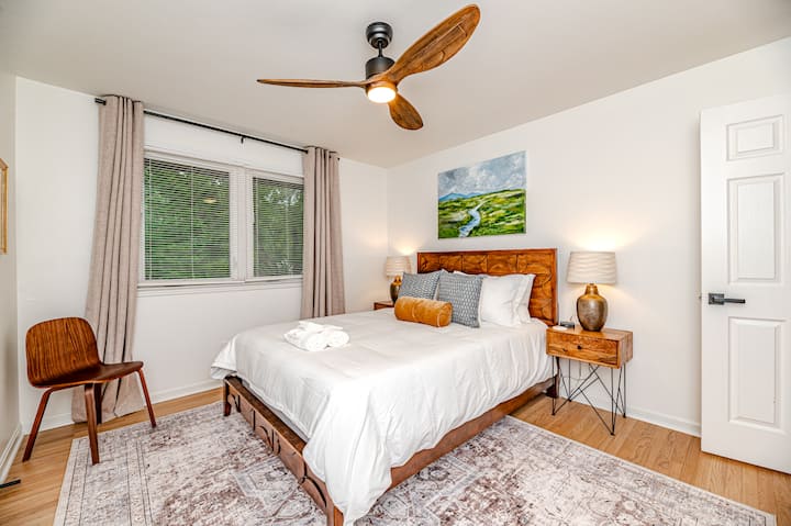 One queen bed with a beautiful painting created by a local artist. Two bed side table lamps for extra, delicate lighting and gorgeous bedside tables. Enjoy the over head fan and black out window shades for a restful slumber.