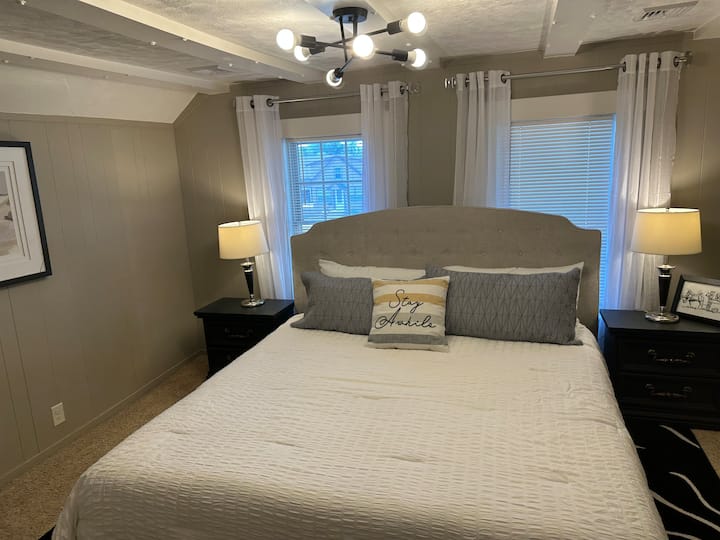 Chambre confortable avec très grand lit, un éclairage élégant et un décor doux et raffiné