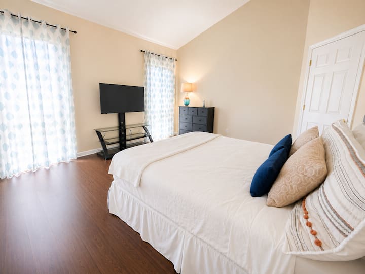 Unwind in the spacious master bedroom featuring a comfortable queen-size bed designed for a restful night’s sleep.