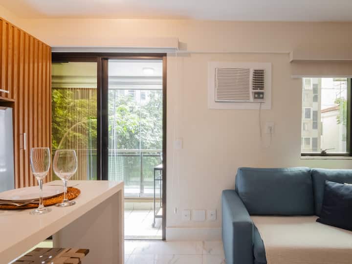 Sala de estar aconchegante com ar-condicionado, Wi-Fi, TV Smart e sofá-cama, integrada à cozinha para maior conforto e praticidade durante a estadia.