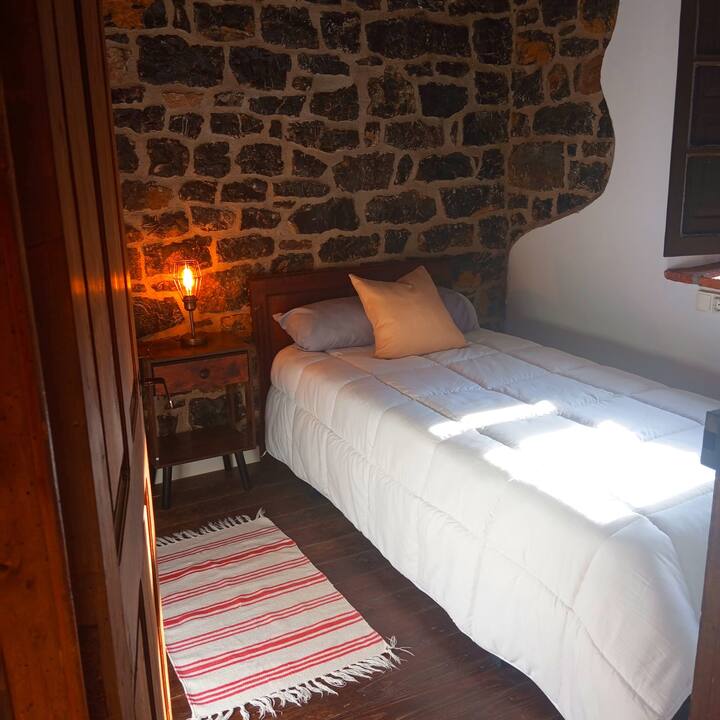 Dormitorio 3 de ambiente acogedor con lámpara cálida y alfombra.
