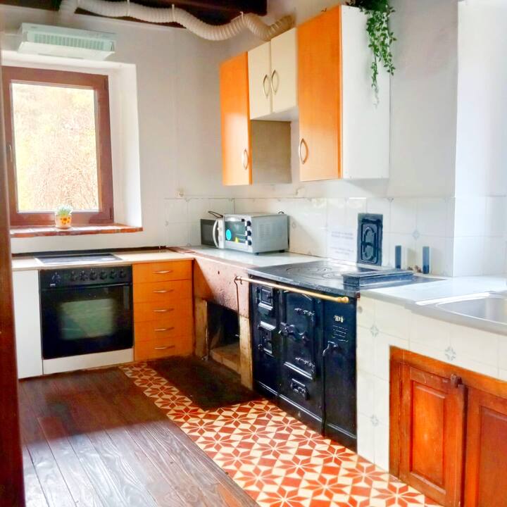 Cocina equipada con horno y antigua cocina de hierro: el encanto rural intacto.