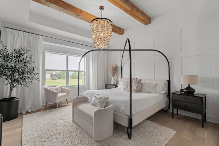 Luxurious primary suite with vaulted beams and elegant designer touches.
