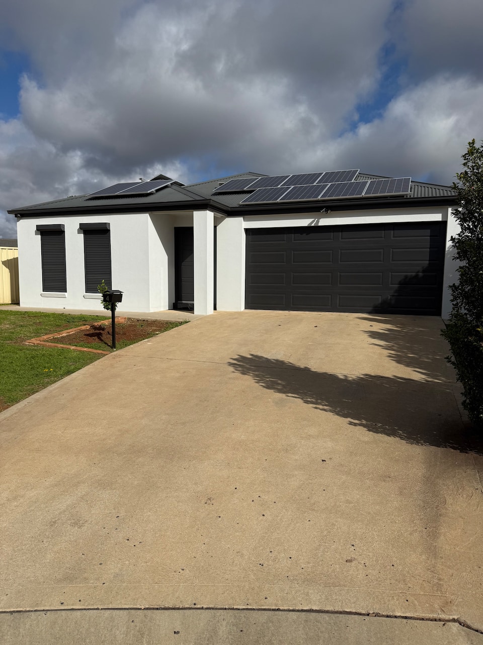The Holiday Home Griffith exterior with a double garage and front lawn
