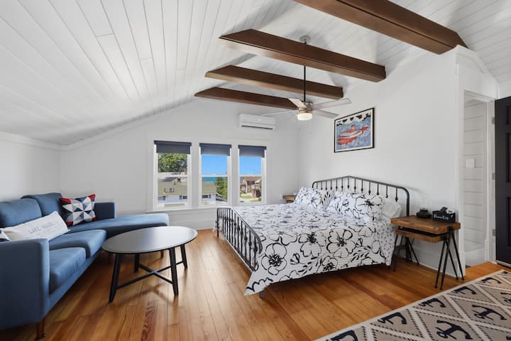 Spacious and inviting "Suite 6", this third-floor loft suite features a comfortable king bed, cozy sitting area, mini-split AC, and beautiful views of the nearby waterfront.
