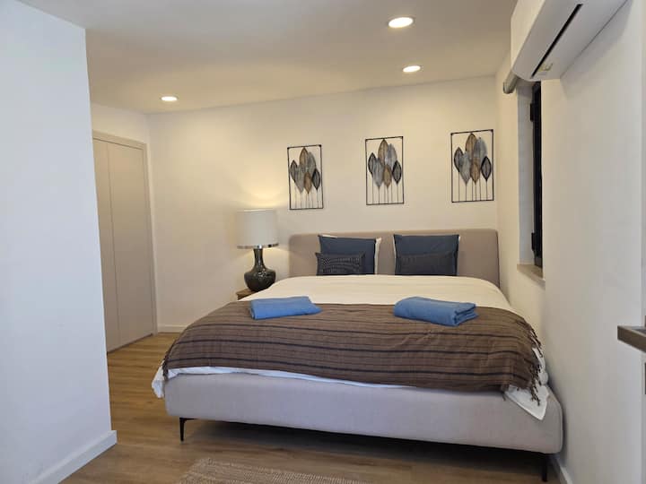 Dormitorio con cama tamaño king (180x200), baño “en suite”, aire acondicionado, un armario y acceso directo a la terraza de la azotea.