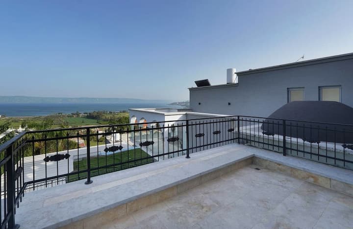 Une terrasse spacieuse avec une balustrade en fer et une vue panoramique sur la mer