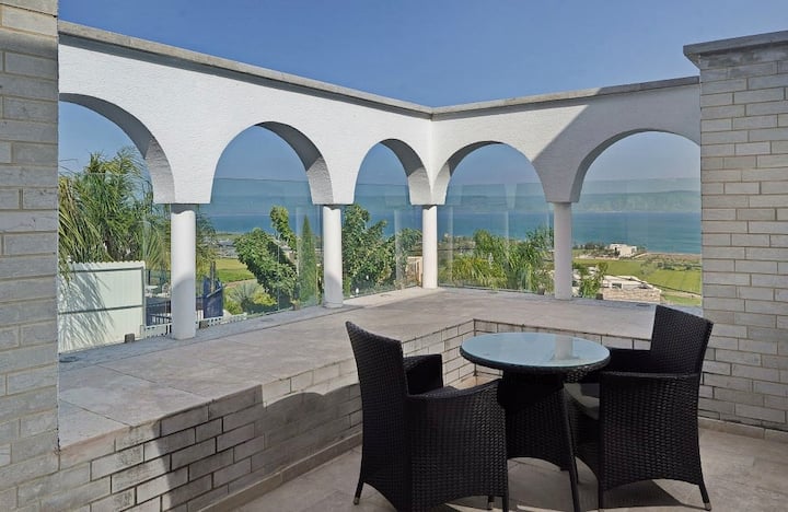 Terrasse spacieuse avec des arches blanches et une vue panoramique sur la mer