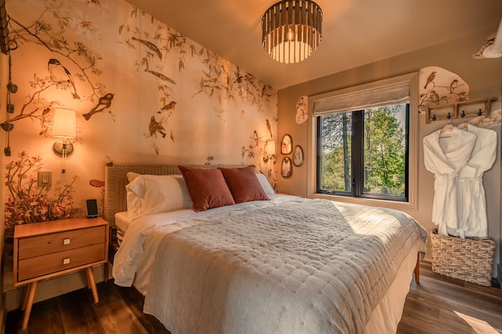 Drift off in this cozy woodland-inspired bedroom, featuring a plush king bed, nature-inspired décor, and peaceful forest views.