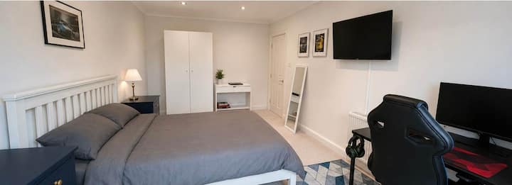 Recámara con cama tamaño king, escritorio y espacio de almacenamiento