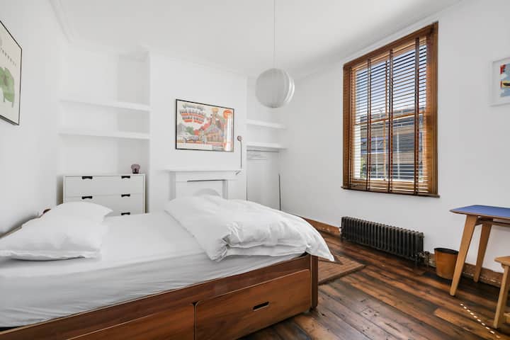Double bed, chest of drawers and hanging rail overlooking garden