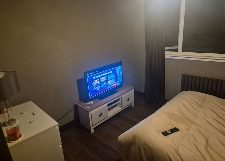 Dhomë gjumi dyshe me krevat dopio, smart TV 36 inç, sirtarë dhe hapësirë.