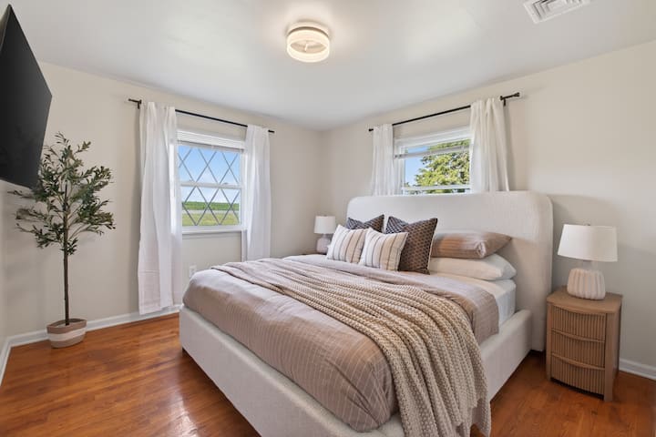 Recámara luminosa y acogedora con una lujosa cama tamaño king, pisos de madera y luz natural