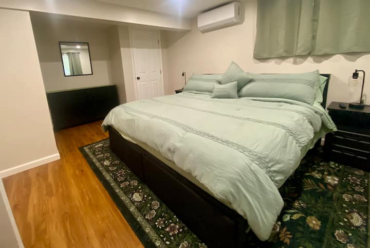 Comfortable king bed, Smart TV, nightstands with built-in charging ports, dresser, mirror, and a mini-split for personalized heating and cooling.