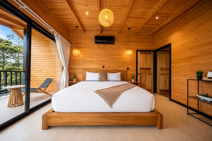 Desfrute do máximo conforto com uma cama king size, banheiro privativo com pia dupla, cafeteira e uma varanda privativa com área de estar e vista para o Vulcão Arenal e o Cerro Chato.