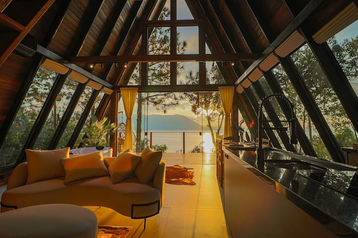 Sala e cozinha com vista para o mar ao pôr do sol