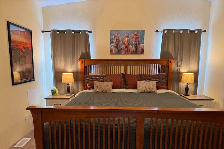 Master bedroom with King size bed and end tables, with lights and USB plugs for charging devices.