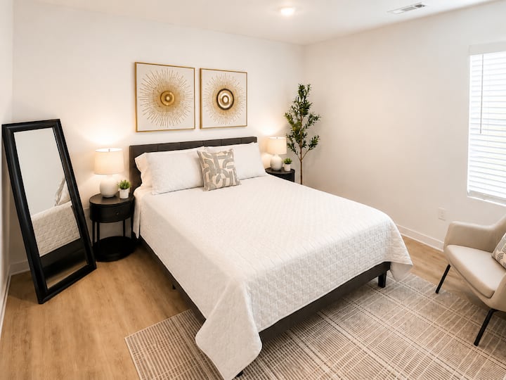Habitación luminosa y moderna con cama tamaño queen, detalles acogedores y decoración elegante