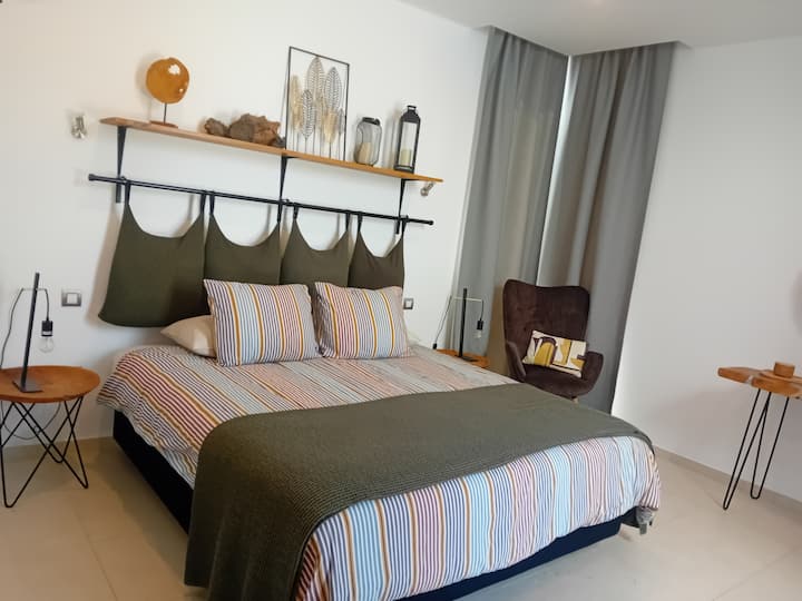 Amplia recámara principal con cama matrimonial, clósets empotrados, mesas de cabecera, tocador y silla, además de aire acondicionado. Las puertas francesas dan directamente a la alberca y a la zona del patio (planta baja).