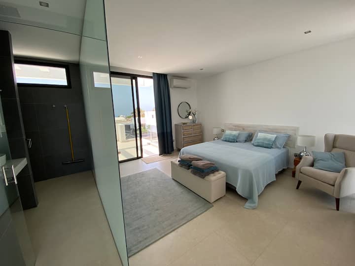 Amplia habitación doble con clóset empotrados, mesas de cabecera, TV y aire acondicionado. Las puertas francesas conducen a una amplia terraza superior (primer piso).