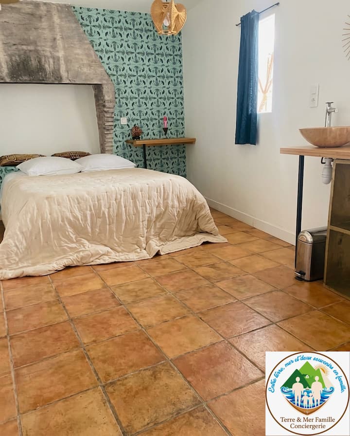 Habitación doble atípica con un encanto auténtico, con su piso de terracota y su arco de piedra. Disfrute de una cama acogedora y de un área privada con lavabo y ducha para una estadía original y con todas las comodidades.