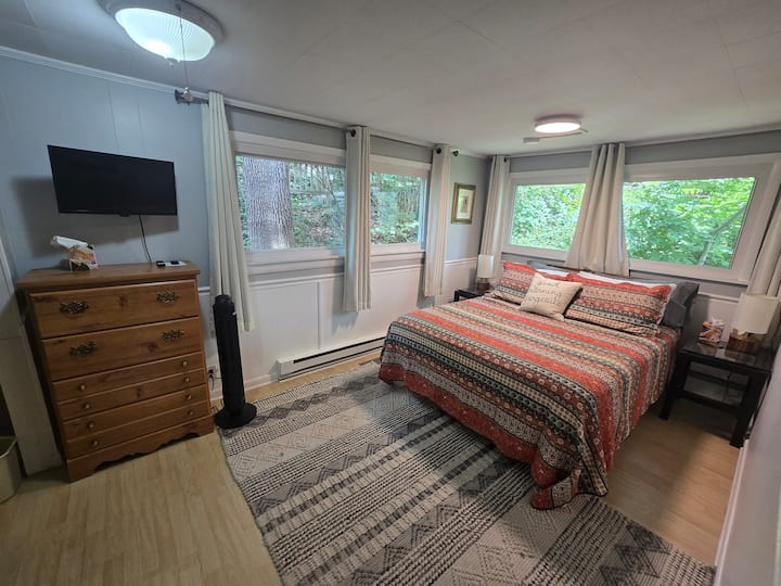 Lujosa cama tamaño queen con cortinas que oscurecen la habitación.