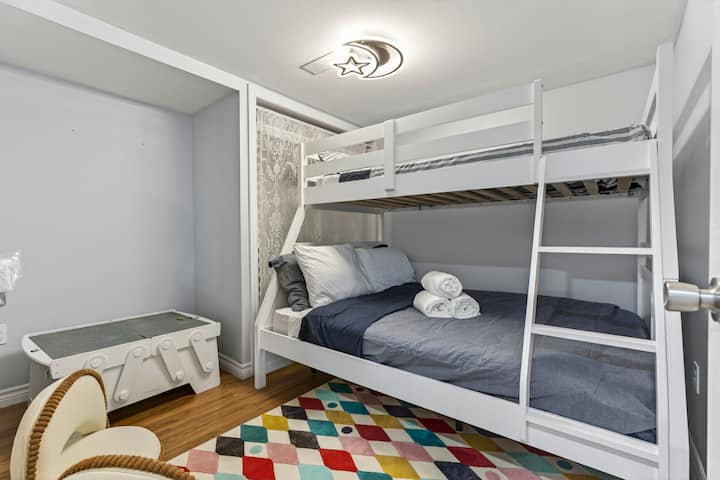 Family-friendly bunk room with colorful rug and playful moonlight