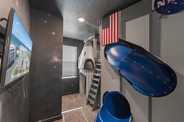 ¡Deja que tus pequeños astronautas se deslicen por el tobogán en la habitación con literas espaciales! Una litera en forma de cápsula espacial, una bandera de la NASA y un tobogán tubular: la habitación de la que hablan los niños en todas las evaluaciones.