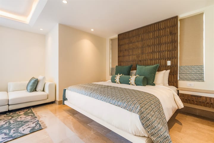Bedroom — king bed with carved wood headboard, green pillows.  This is a guest house.  Must be reserved by separate request.