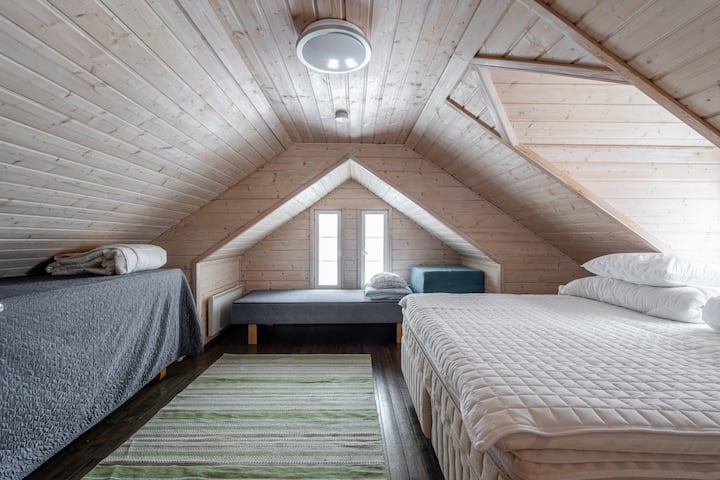 Los rincones para dormir bajo el techo inclinado están acabados con superficies de madera cálida.