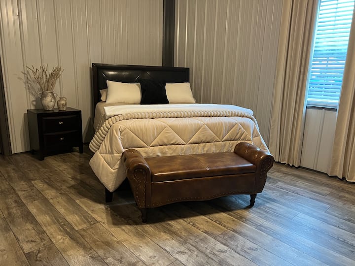 Spacious queen bedroom with luxury bedding, premium furnishings, blackout curtains, and rustic Appalachian charm for a peaceful night's rest after riding the trails.