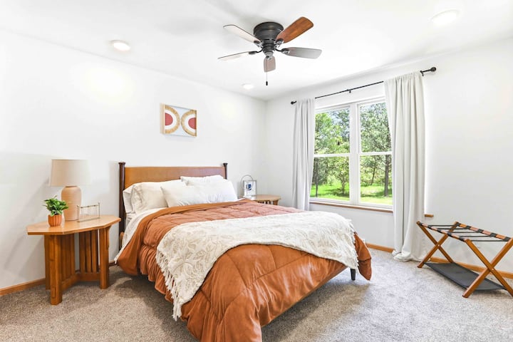 Despiértate con una suave luz natural y vistas tranquilas a las copas de los árboles en un dormitorio cálido y acogedor diseñado para disfrutar de mañanas relajantes.
