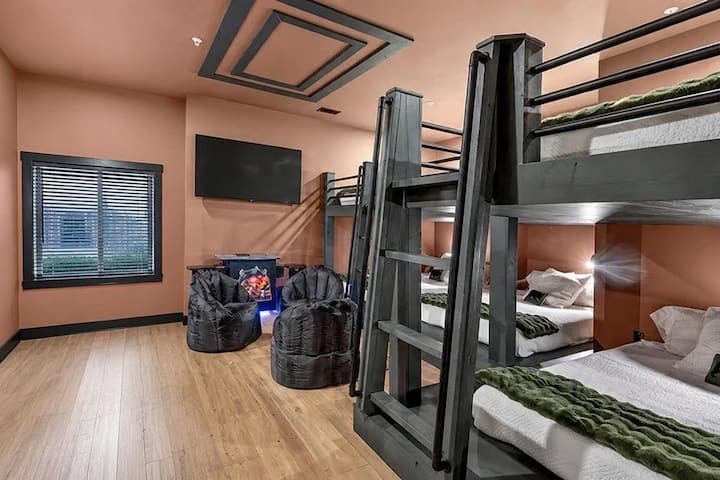 Dhomë e gjerë me krevate dykatësh dhe kënd ndenjeje me TV, e përkryer për grupe dhe familje