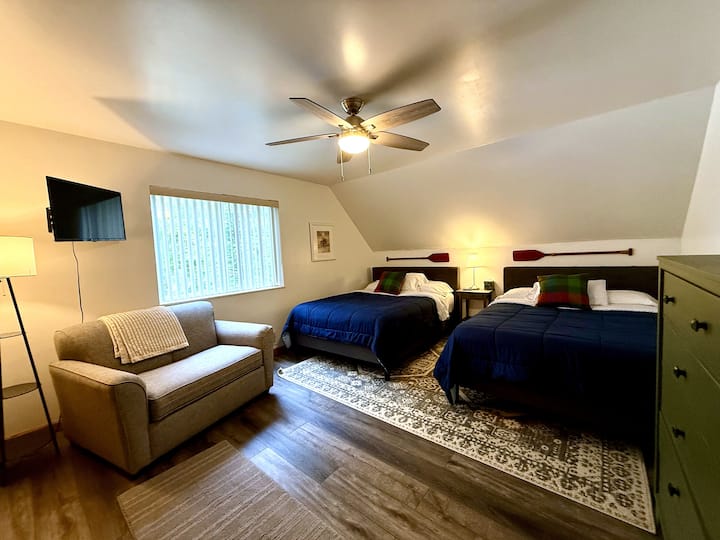 Chambre au deuxième étage avec deux lits queen size et un canapé-lit simple — peut accueillir jusqu'à cinq personnes, avec vue sur le lac.