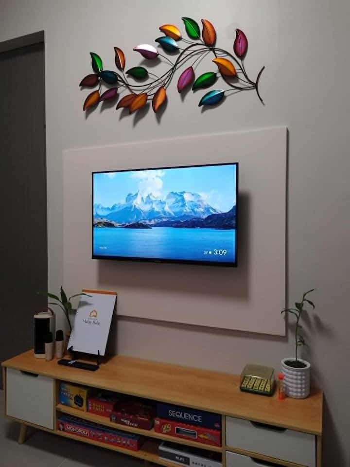 Cozy minimalist living space featuring a smart TV, and a selection of fun board games for staycations.