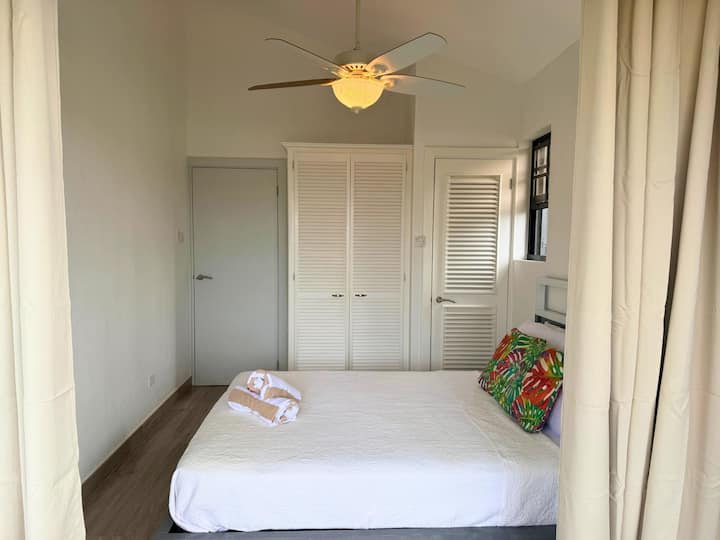 Quarto minimalista e iluminado com tetos abobadados e armazenamento embutido