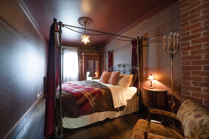 With its four-poster bed, brick walls, and warm atmosphere, this fifth bedroom offers a peaceful retreat in the heart of the manor.