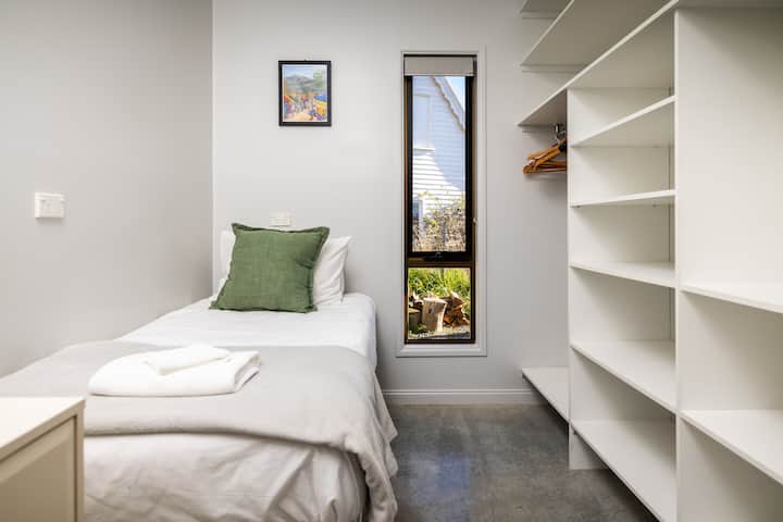 Compacta pero cómoda, esta habitación individual cuenta con mucho espacio para colgar ropa y una cama nido opcional.