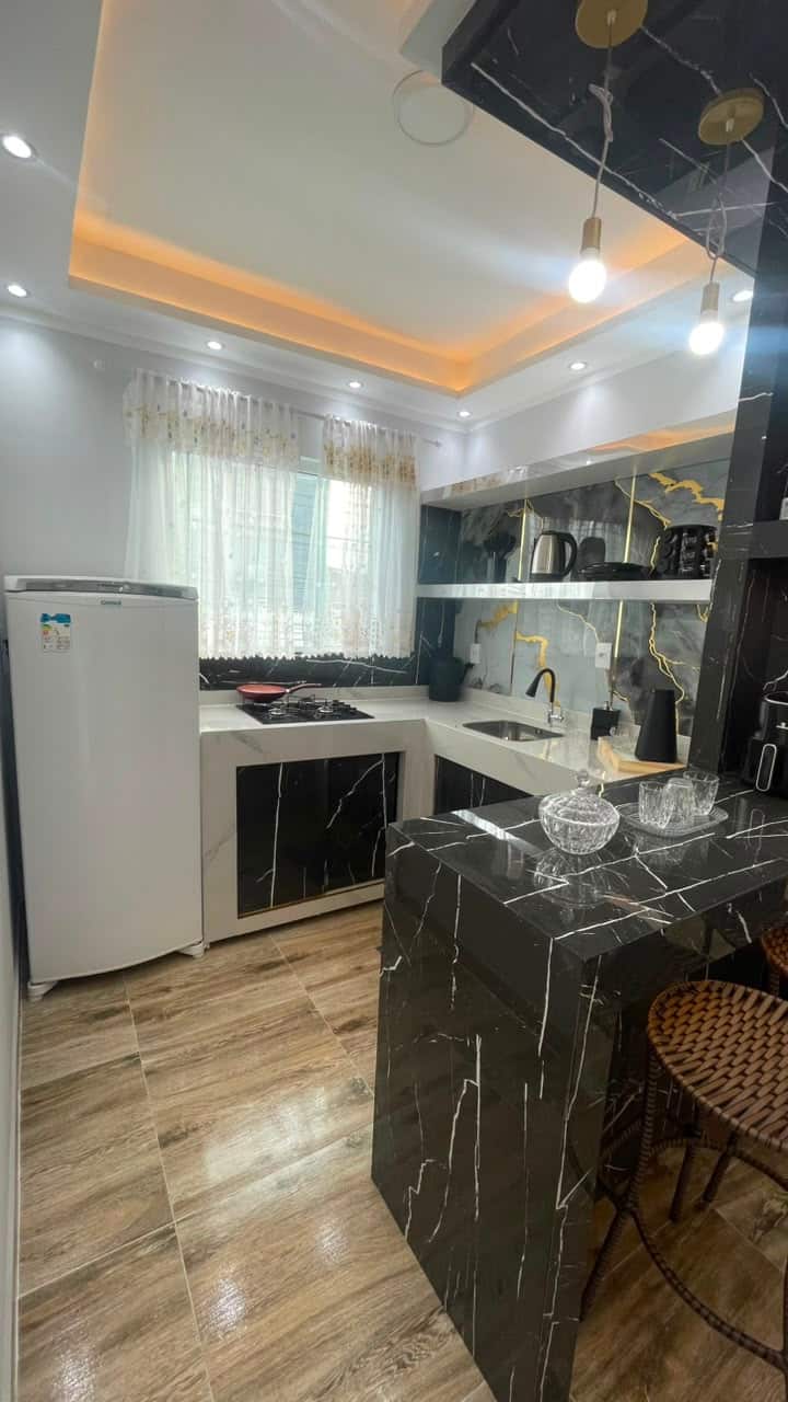 Cozinha americana com mármore preto e dourado