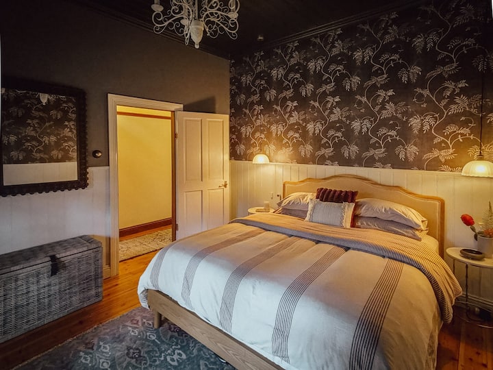 Luxurious King bedroom with heritage charm and moody elegance.