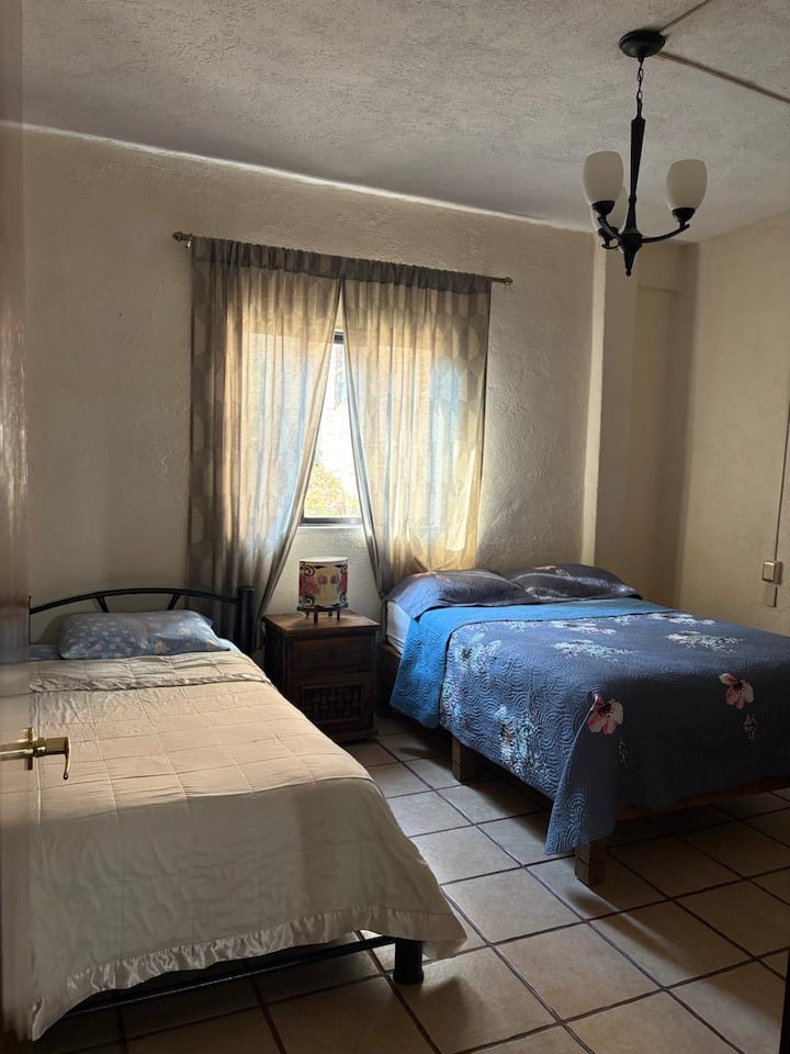 Dhomë e rehatshme, e ndriçuar dhe e ajrosur, e pajisur me një krevat dopio, një krevat tek dhe një dollap për të vendosur bagazhet dhe rrobat.  Dyshekë dhe jastëkë të rinj për më shumë rehati
