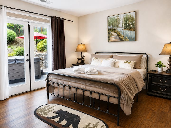 Step into the inviting master bedroom with a king-size bed! This space flows onto an outdoor deck, right next to the hot tub, inviting you to unwind and soak in the tranquil atmosphere.
