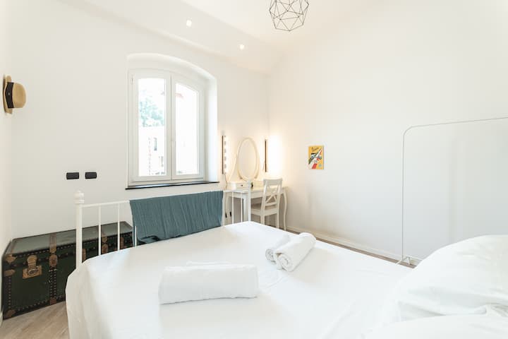 Letto con baule vintage e finestra luminosa