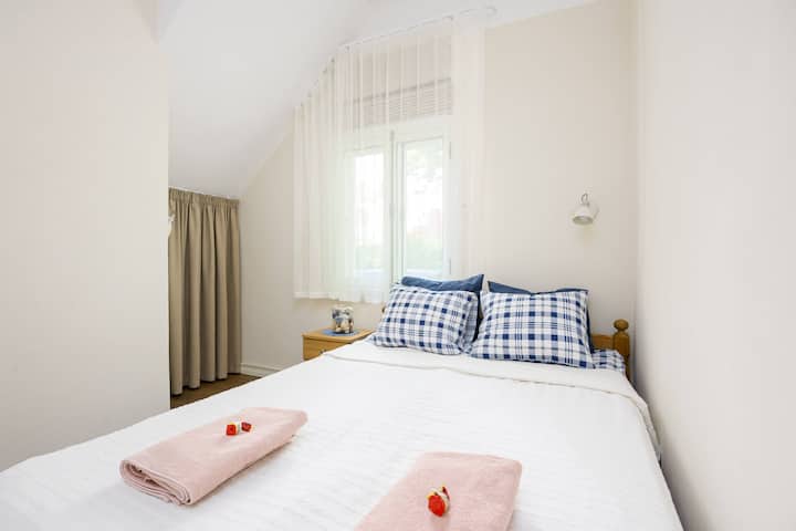Cama del dormitorio (160x200).
Detrás de las cortinas beige hay una cama de viaje para niños. También se pueden colocar ahí las maletas de viaje.