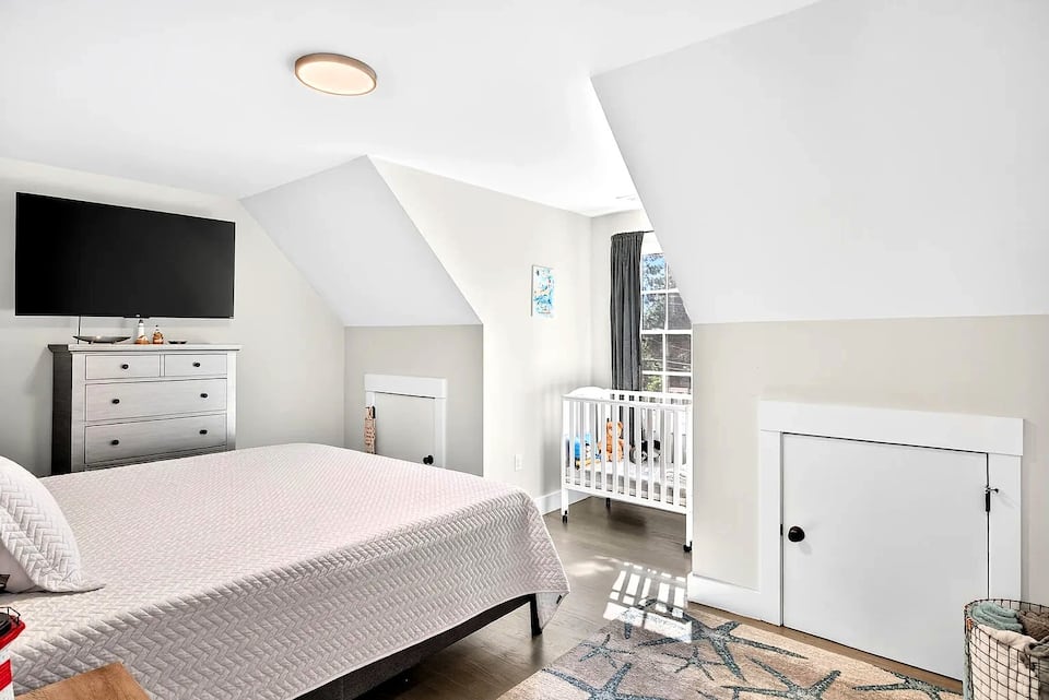 King bedroom with crib and smart TV