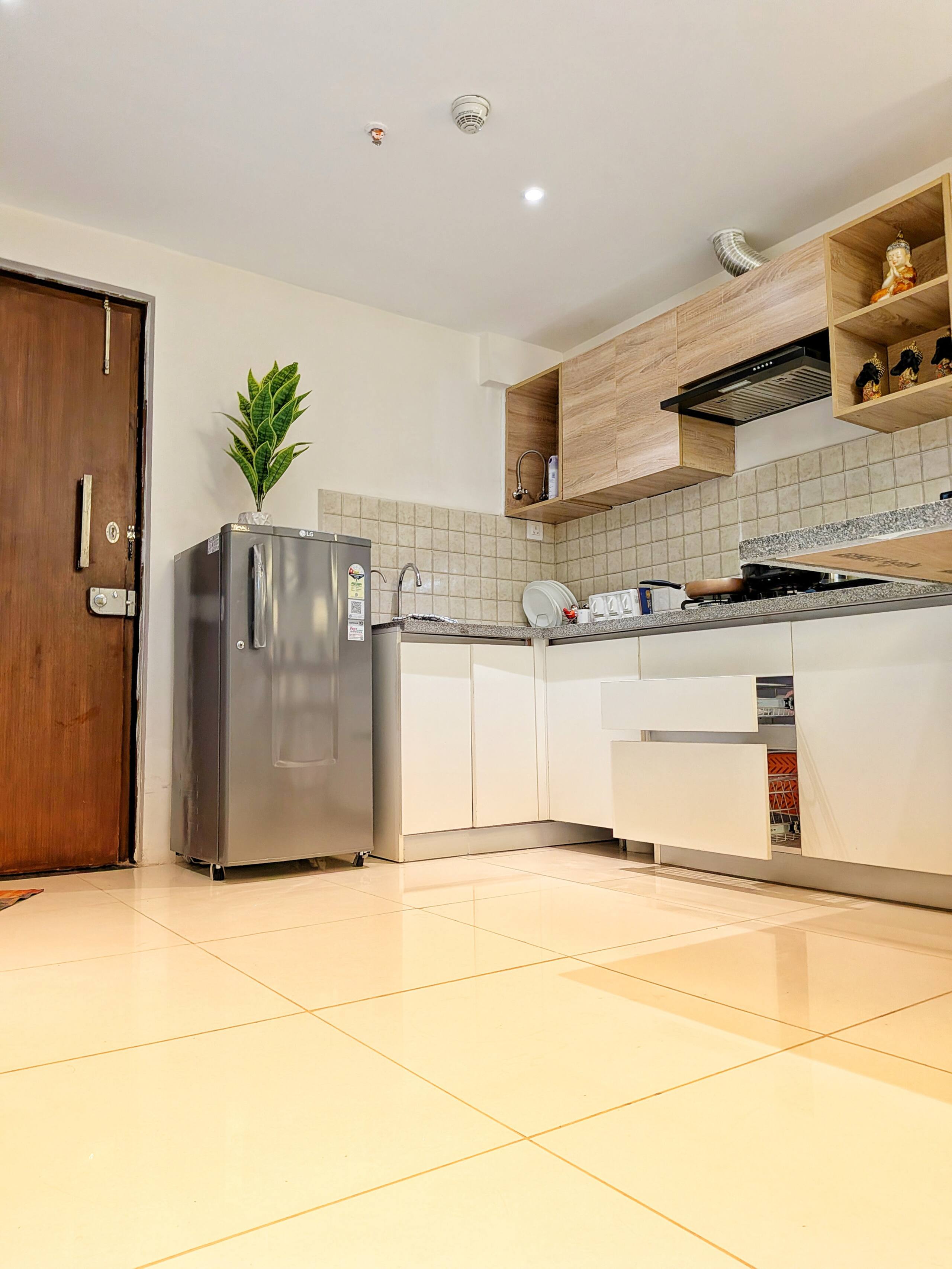 Modular L-shaped kitchen with refrigerator, white base units and oak-finish wall cabinets