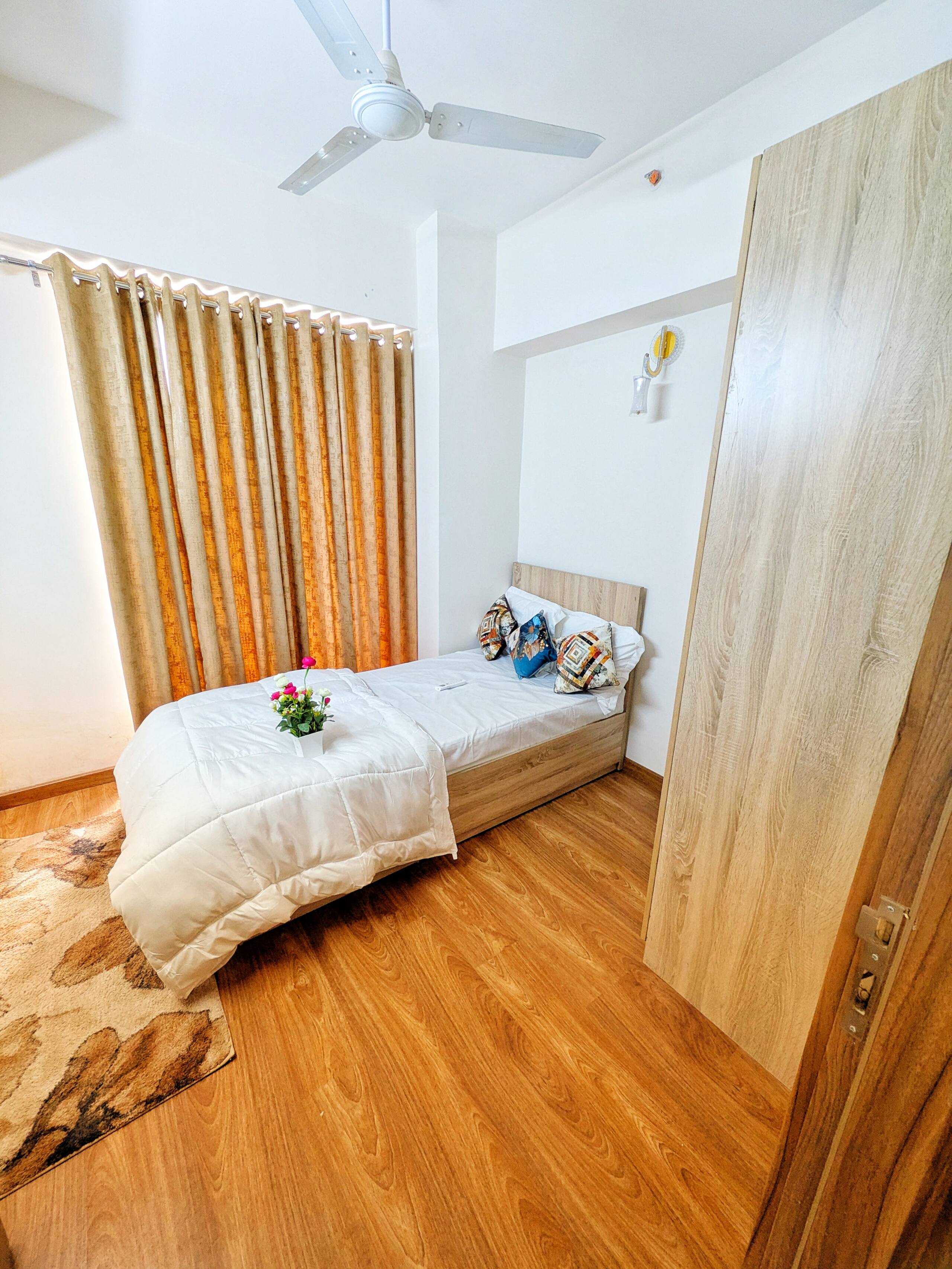 Second bedroom with single bed, curtains and wardrobe
